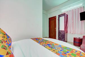 a bedroom with a bed with a colorful blanket at Via Pink House in Pune
