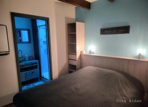 una camera da letto con un letto grande e uno specchio di Le Gite Aïdan a La Puye