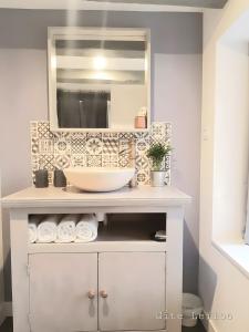 un bagno con lavandino e specchio di Le Gite Leiloo a La Puye