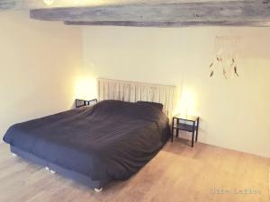 una camera da letto con un letto grande e due comodini di Le Gite Leiloo a La Puye