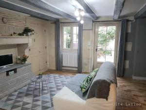 un soggiorno con un divano e una TV di Le Gite Leiloo a La Puye