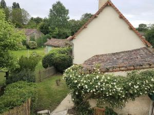 una casa bianca con dei fiori sul lato di Le Gite Leiloo a La Puye
