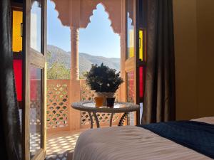een slaapkamer met een bed en een tafel met een raam bij Hotel Santosh Heritage in Pushkar