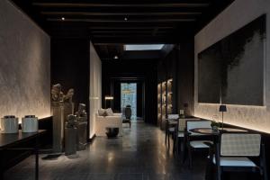 a restaurant with black walls and tables and chairs at Soori Penang in George Town +6 photos