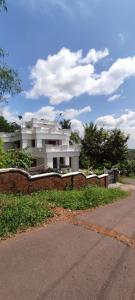 a large white building in front of a building at A CLASS King bedroom with balcony view, extra bed, and a spacious bathroom with changing area in Chakkarakkal