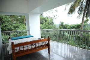 a porch with a bed on a balcony at A CLASS King bedroom with balcony view, extra bed, and a spacious bathroom with changing area in Chakkarakkal