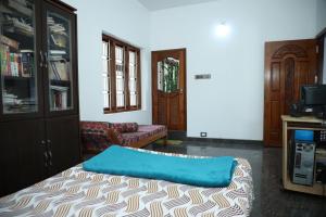 a room with a bed with a blue pillow on it at A CLASS King bedroom with balcony view, extra bed, and a spacious bathroom with changing area in Chakkarakkal