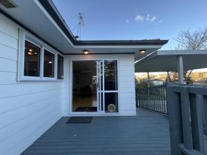 um alpendre frontal de uma casa com uma porta de vidro deslizante em The Sweet Pea- Room 4 em Hamilton