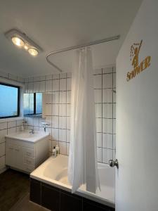 um banheiro branco com banheira e pia em The Sweet Pea- Room 4 em Hamilton