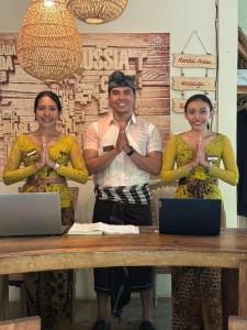 three people standing in front of a table with their hands up at Incense Impossible Beach Boutique Hotel - Adults Only in Uluwatu +112 photos
