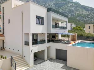 a large white house with a swimming pool at Villa Bacula in Veliko Brdo