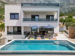 a house with a swimming pool in front of a house at Villa Bacula in Veliko Brdo