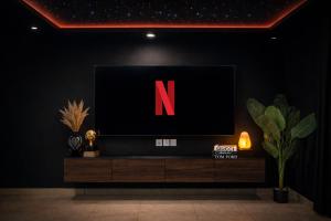 ein Fernseher mit dem Buchstaben N auf schwarzer Wand in der Unterkunft Presidential Suite In Gold Crest Residency-DHA Phase 4 Lahore in Lahore