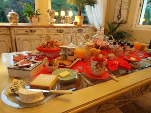 Chailly-en-BièreにあるVilla La Clef Des Champsのチーズなどの食べ物や飲み物を揃えた朝食用テーブル