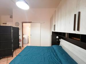 a bedroom with a blue bed and white cabinets at porta merlonia house grazioso monolocale in Forlì