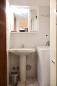 un bagno bianco con lavandino e WC di porta merlonia house grazioso monolocale a Forlì