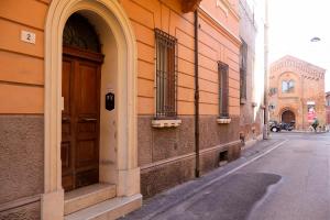 un edificio arancione con una porta sul lato di una strada di porta merlonia house grazioso monolocale a Forlì