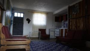 ein Wohnzimmer mit 2 Stühlen und einer Tür in der Unterkunft Oldonyo Musa Camp Amboseli in Rift Valley