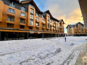 a snow covered street in front of a building at New Gudauri Redco F1 in Gudauri +4 photos