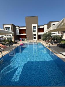 a large blue swimming pool in front of a building at Eva Apart Kemer in Kemer