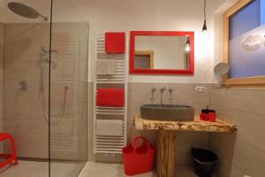 a bathroom with a sink and a shower with a mirror at Bucherhof in Marlengo