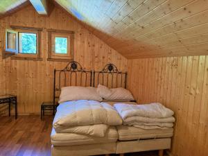 Un dormitorio con una cama en una pared de madera. en Chalet alpin authentique au cœur du Valais, Hérémence, en Saint-Martin