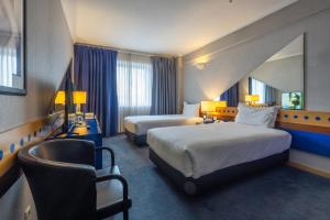 a hotel room with two beds and a chair at Hotel 3K Barcelona in Lisbon +86 photos
