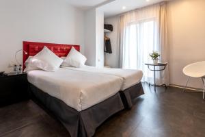 ein Schlafzimmer mit einem großen Bett mit rotem Kopfteil in der Unterkunft Mayerling Hotel in Madrid