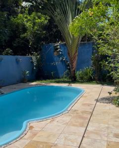 een zwembad in een achtertuin met een blauw hek bij Casa de Cura in Pipa