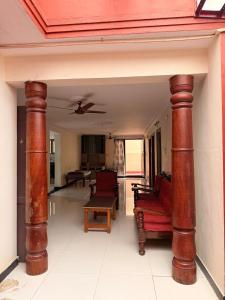 un soggiorno con due grandi colonne di legno in una casa di Happy cheerful homes a Mysore