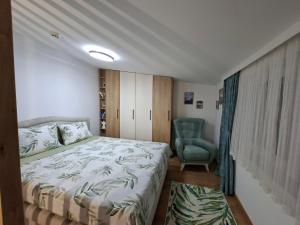 a bedroom with a bed and a green chair at Vikvid in Kopaonik