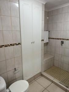 ein Badezimmer mit Toilette und Dusche in der Unterkunft 37 Laguna La Crete in Margate + 11 Fotos