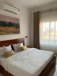 NārāyanpurThe Cub Sariska的卧室里有一张白色的大床，床边有一扇窗户