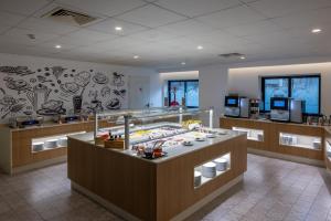 a restaurant with a food counter in a store at Hotel 3K Barcelona in Lisbon