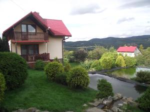 ein Haus mit einem Fluss davor in der Unterkunft Domek u Jana in Istebna