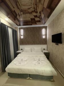 une chambre avec un grand lit et une télévision à écran plat dans l'établissement Royal Fsm Suites, à Istanbul