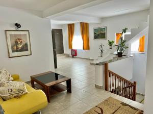a living room with a yellow chair and a table at Parc Vatra Dornei - Deluxe Suite in Vatra Dornei