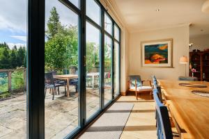 een eetkamer met grote ramen en een tafel met stoelen bij Glenardle Lodge in Bridge of Cally