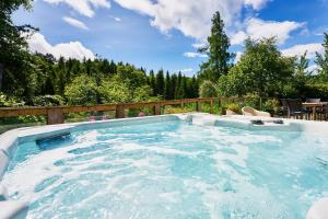 een hottub in een achtertuin met een houten hek bij Glenardle Lodge in Bridge of Cally