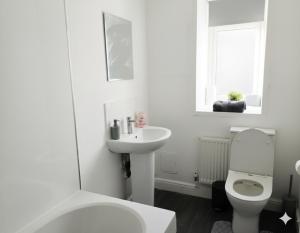 a white bathroom with a toilet and a sink at Esk View House,Carlisle in Carlisle