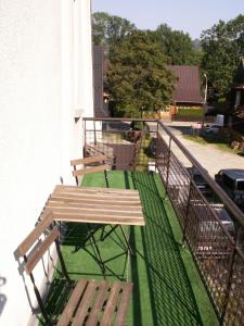 balcón con mesa de madera y 2 bancos en Pokoje Jola Zakopane, en Zakopane