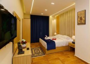 una camera da letto con un letto e una TV a schermo piatto di rizkyan pyramids view INN a Il Cairo Altre 23 foto