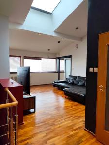 een woonkamer met een zwarte bank en een televisie bij Lucky 55 in Praag