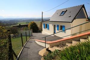 een klein wit huis met blauwe ramen en trappen bij La maison de madeleine in Livron
