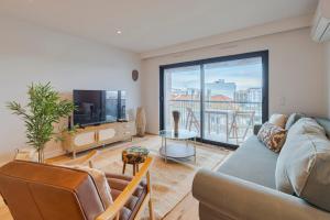 un soggiorno con un divano e una TV di Lume Residence W a Setúbal