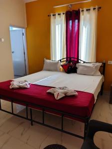 uma cama com dois pares de sapatos sentados nela em Hil min apartment Calangute em Calangute