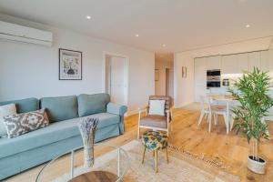 un soggiorno con un divano blu e un tavolo di Lume Residence W a Setúbal