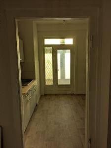 an empty room with a door and a kitchen at Monteurswohnung in Malchin