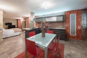a kitchen with a table and red chairs in a room at Dimora Paradiso in Campobasso