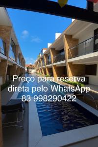 ein Schild an der Seite eines Gebäudes mit Pool in der Unterkunft Bangalô Camboinha triplex in Cabedelo